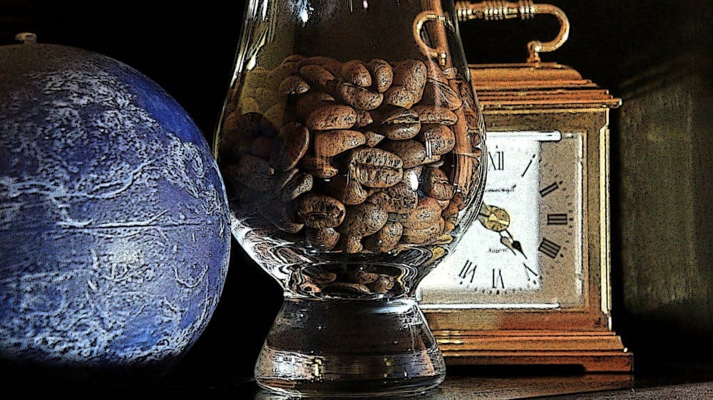 A brass carriage clock with a glass of coffee beans and a blue bottery vase are in the image.