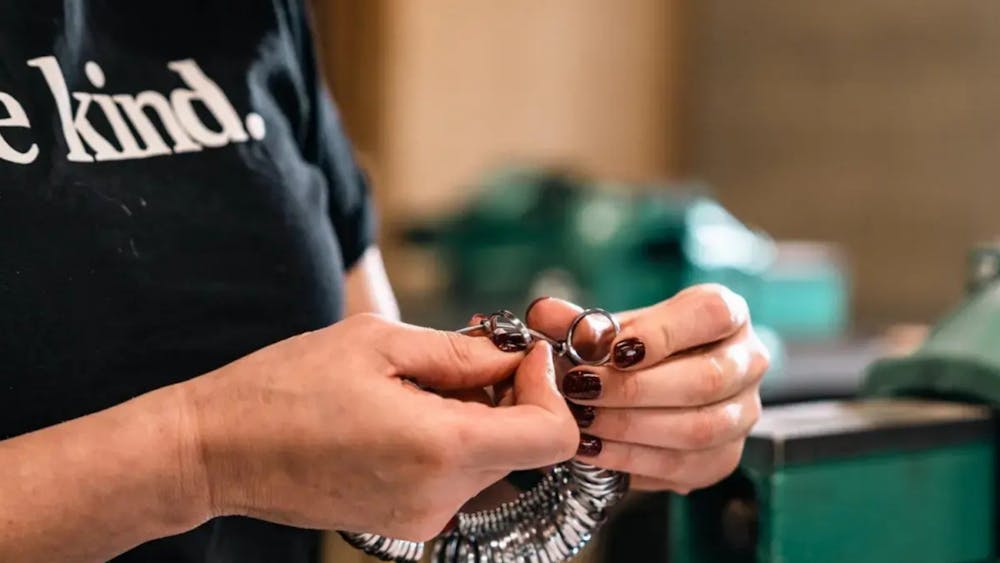 Close up of hands holding a collection of rings on a circular ring holder