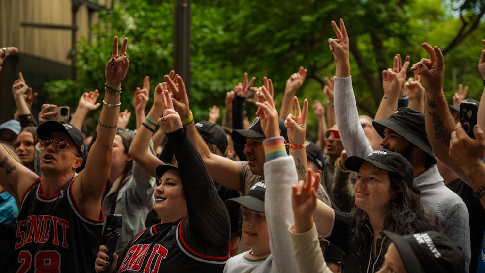 a crowd of people with their hands in the air