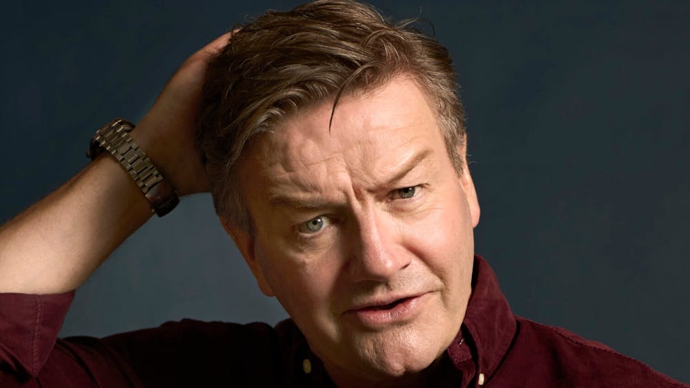 portrait of comedian holding the back of his head