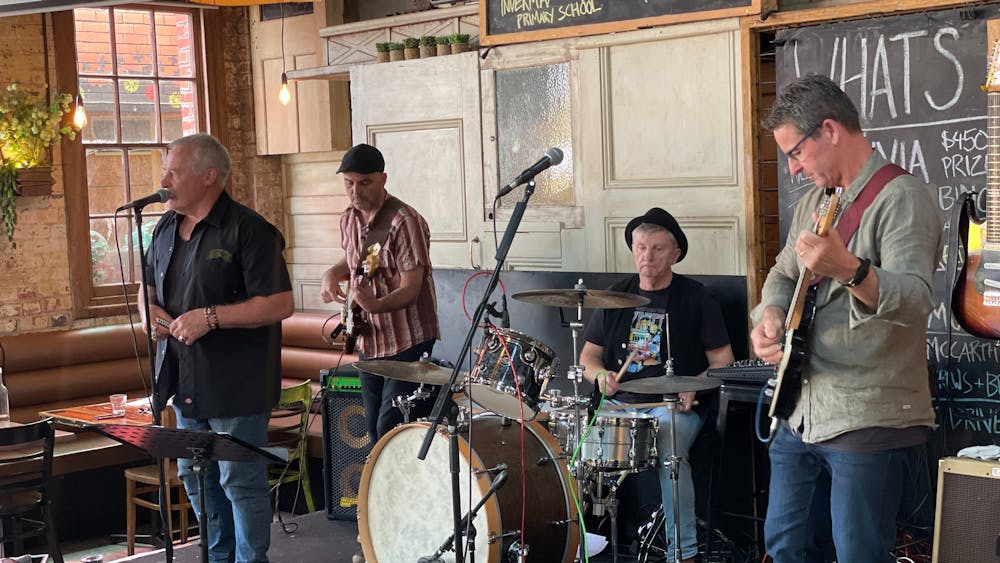 4 musicians stand on the Hop Stage with a variety of Blues instruments.