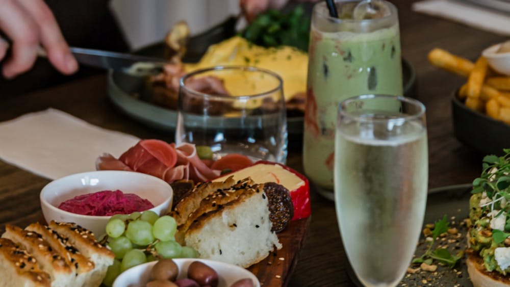 Shared brunch table with a grazing board, seasonal dishes and specialty drinks.