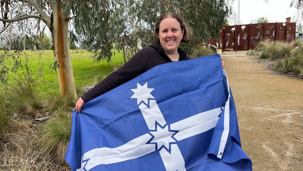 Lauren Powell holding the Eureka Flag in the Eureka Stockade Memorial Park