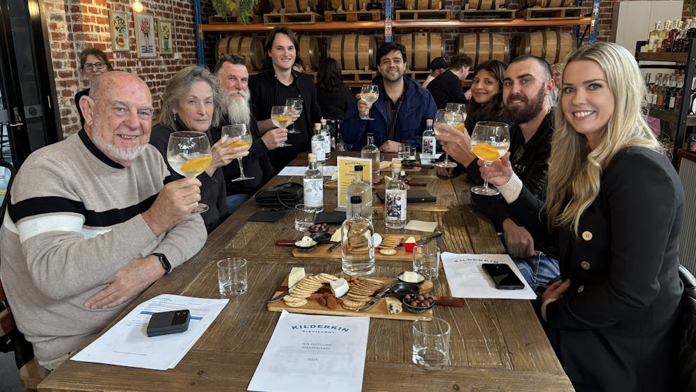 Group of eight people sitting having gin and tonics with cheese