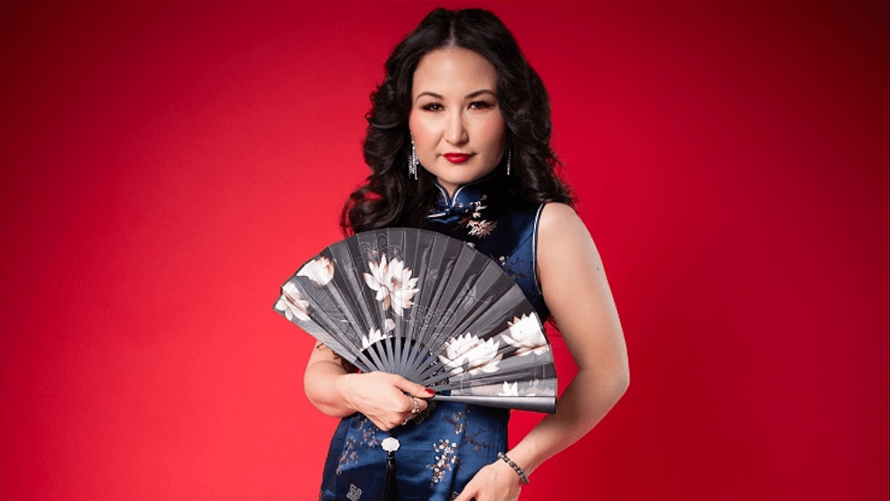 Portrait of astist with fan on red background