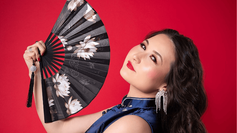 Portrait of artist with fan on red background
