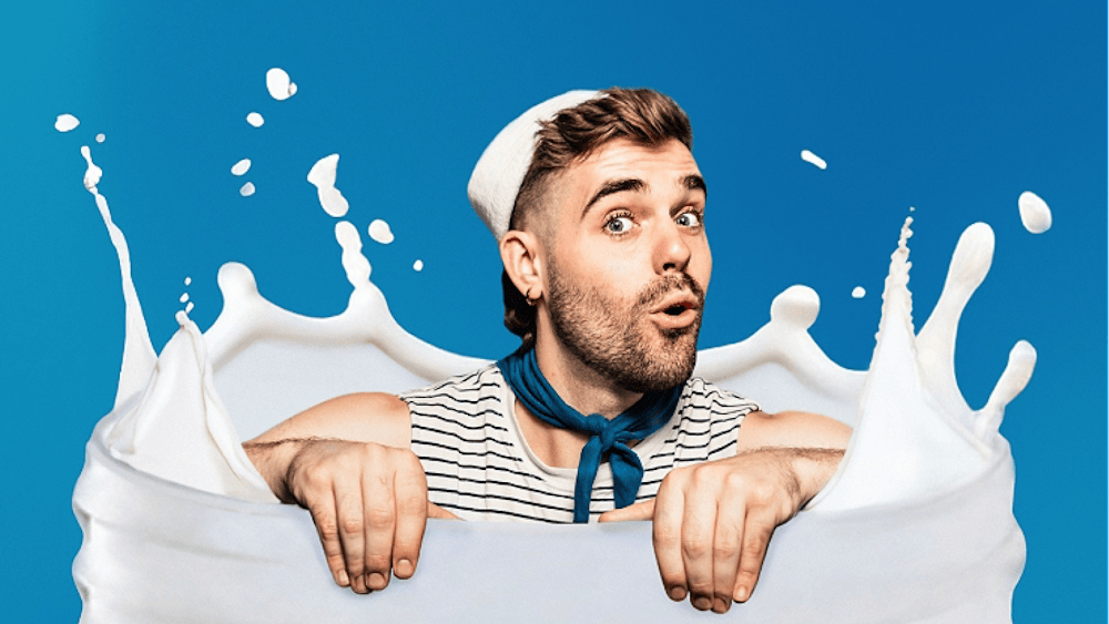Portrait of artist splashing in a milky bottle - in a sailor outfit