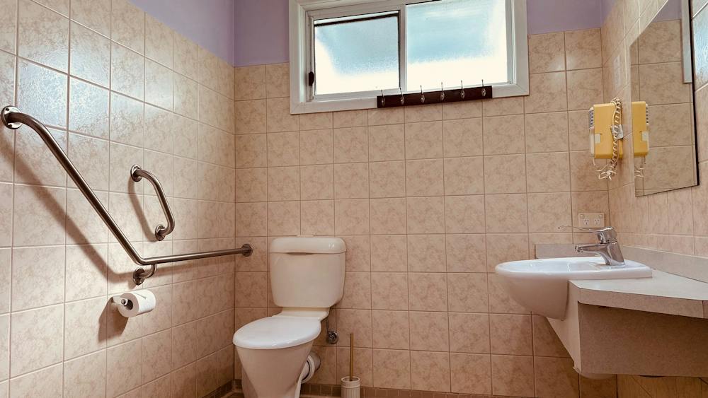 Family Room accessible bathroom with shower, toilet and handrails at Stonez Boutique Accommodation