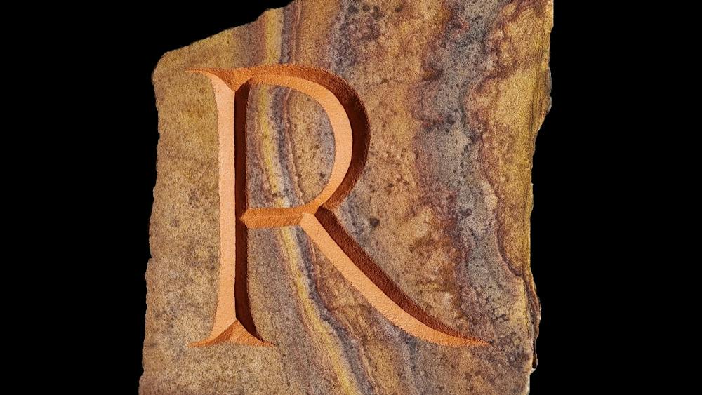 Letter R carved into a stone